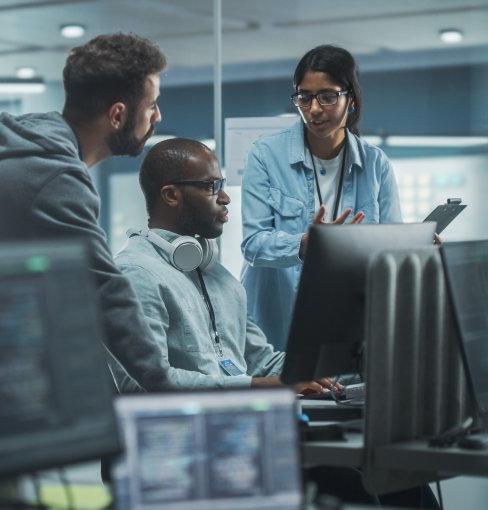 Woman and two men discuss something in computer lab