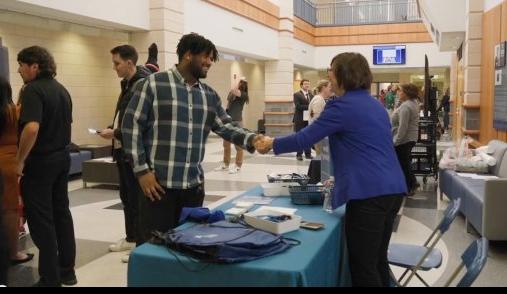 Accountancy professor greets student in School of Business lobby.